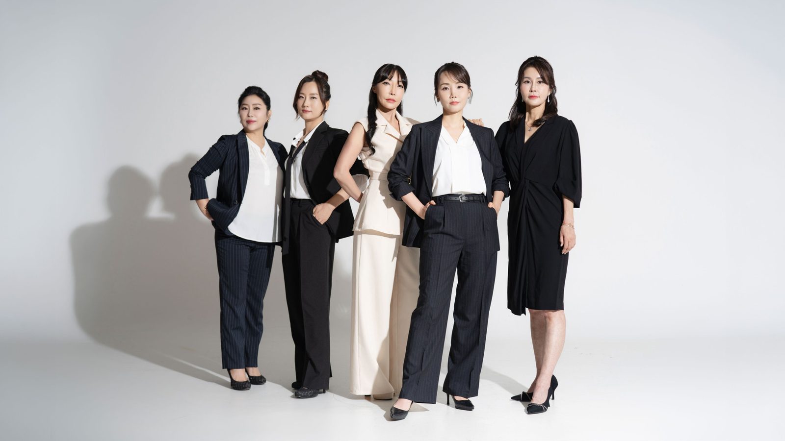 옆 조명으로 벽에 다섯 그림자가 겹친 컷