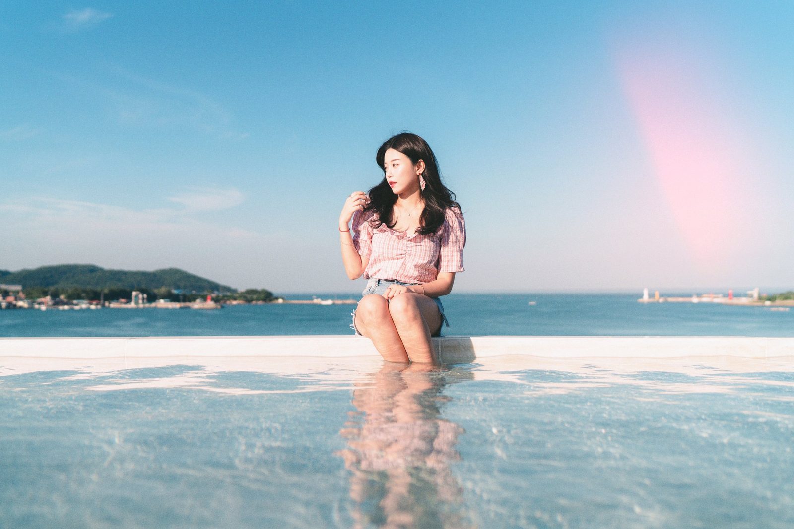 창원 스냅여행사진 — 바다가 보이는 수영장에 걸터앉은 여행 스냅