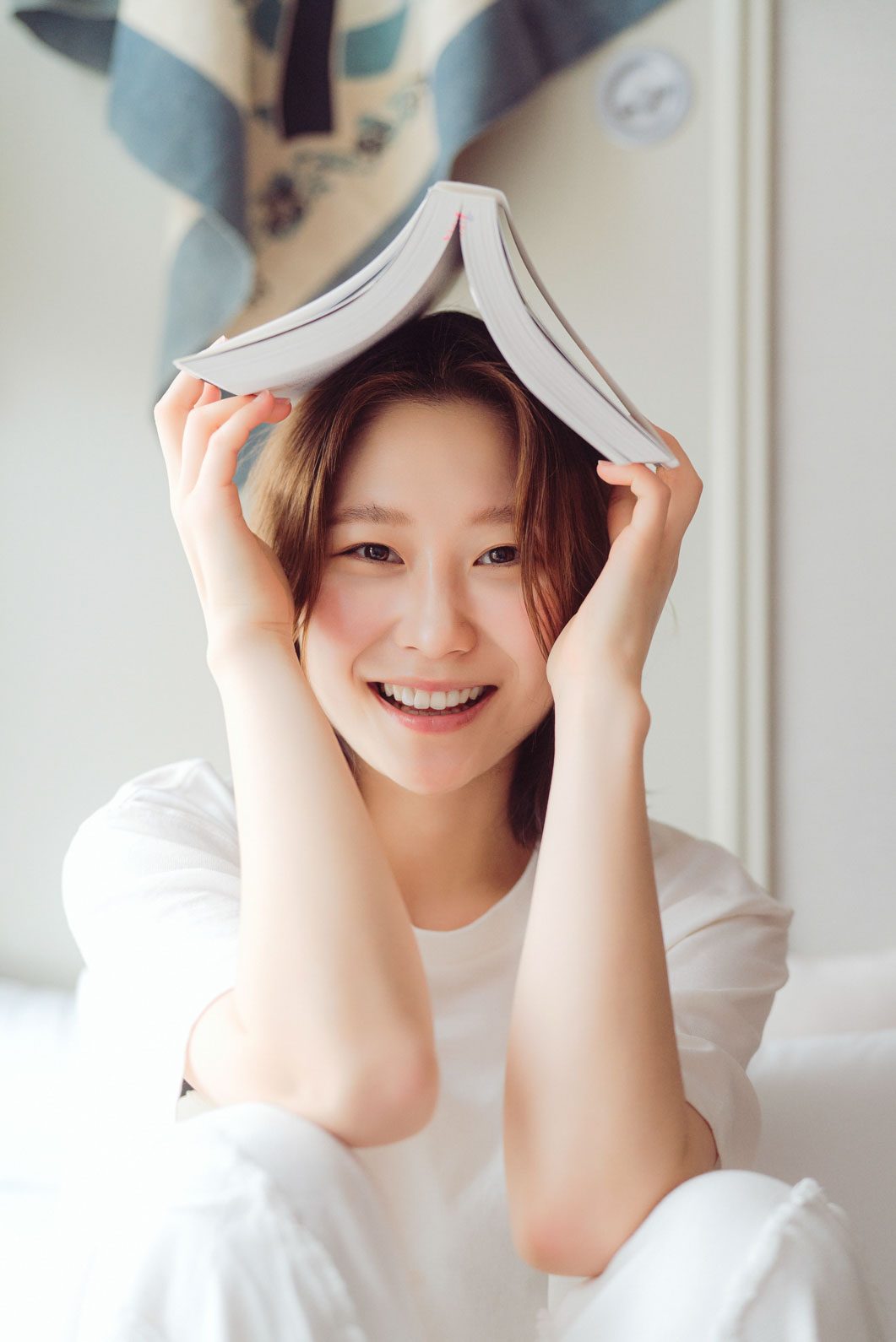 책을 머리에 이고 웃는 컷 — 김스튜디오