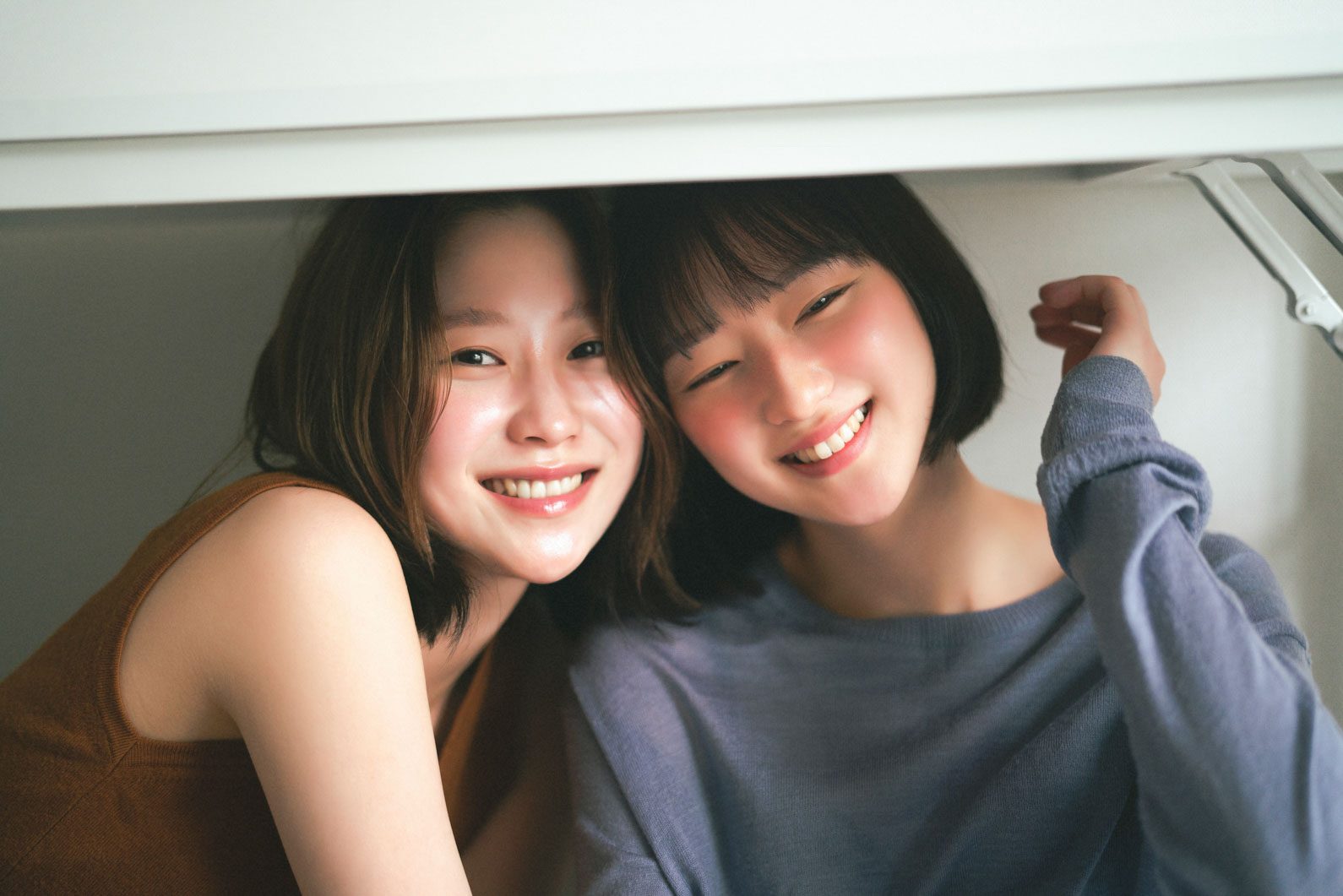 팔을 들어 장난치는 두 사람 — 김스튜디오
