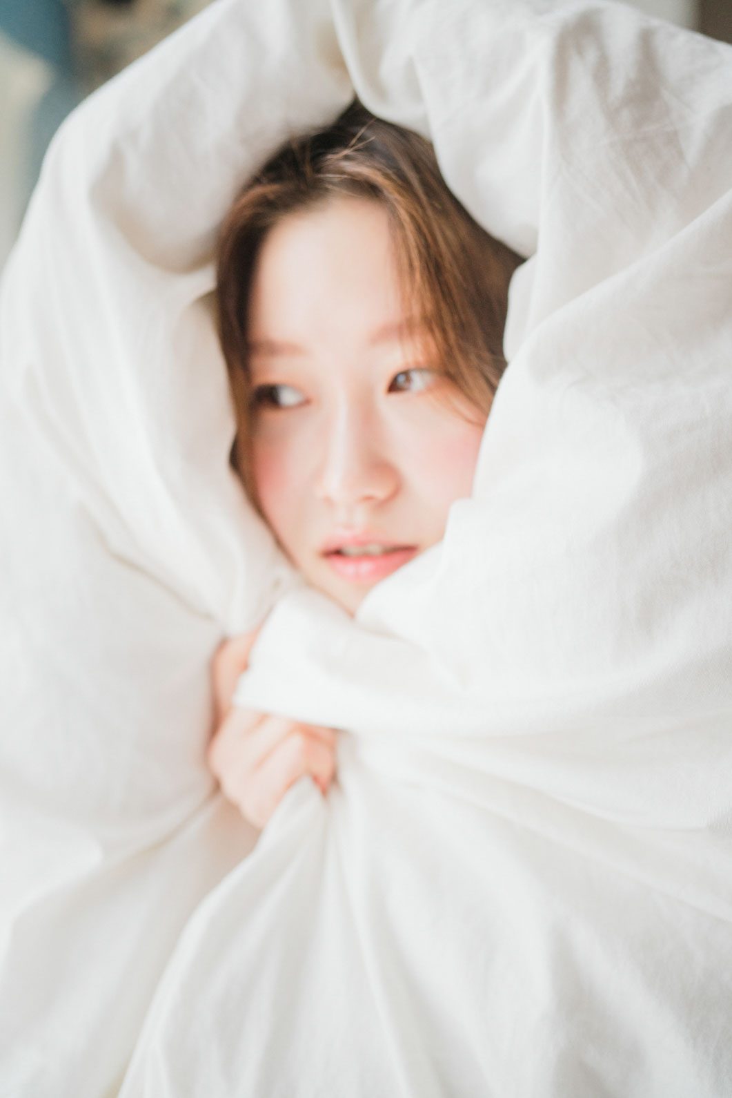 이불을 뒤집어쓰고 카메라를 보는 컷 — 김스튜디오
