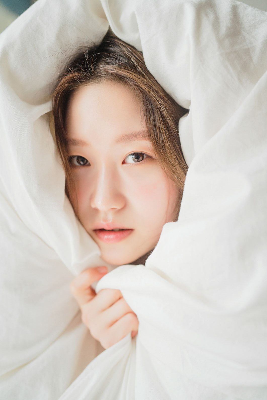이불을 잡고 가만히 앉은 컷 — 김스튜디오